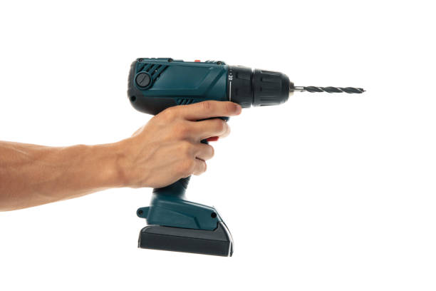 istock Male hand holds cordless drill, isolated on white background 1267309909