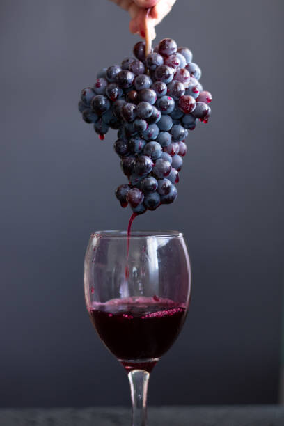 istock Pouring red wine into the glass from the grapes 1267312863