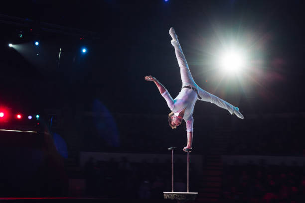 acrobacias aéreas do homem no circus. apresentação circense - acrobatic activity - fotografias e filmes do acervo