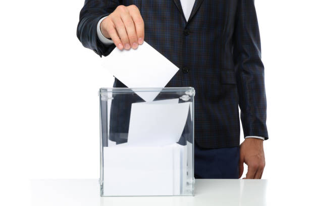 istock Man putting ballot into voting box, isolated on white background 1267314099