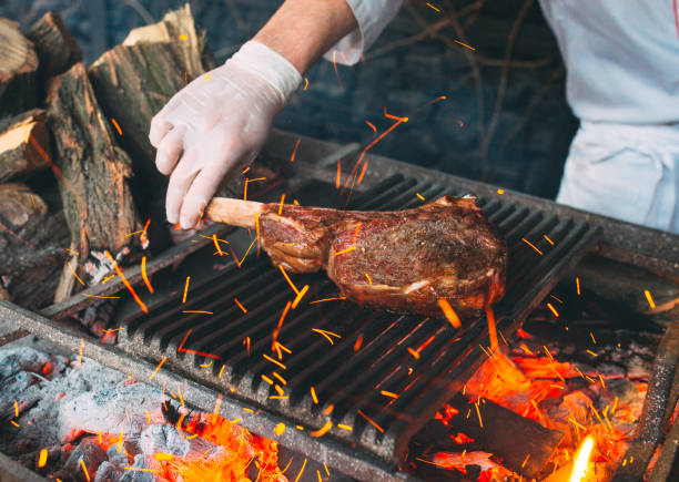 istock Chef Cooking steak. Cook turns the meat on the fire. 1267314401