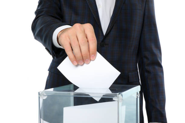 istock Man putting ballot into voting box, isolated on white background 1267316202