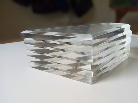 a bunch of acrylic glass in a pile in a room.  clear material with a square shape for craft souvenirs