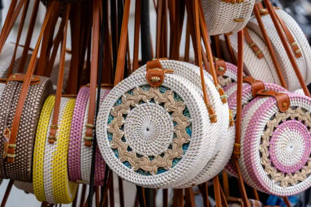 Photo of Famous Balinese rattan eco bags in a local souvenir market on street in Ubud, Bali, Indonesia. Handicrafts and souvenir shop display