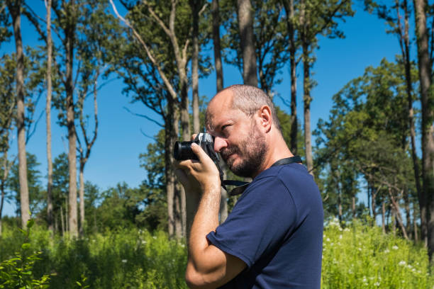istock Man holding mirror less camera and taking photos 1267320965