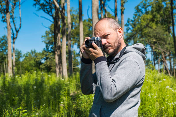 istock Man holding mirror less camera and taking photos 1267321005