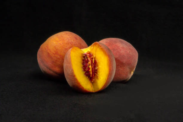 istock Three peaches on a black background 1267322910