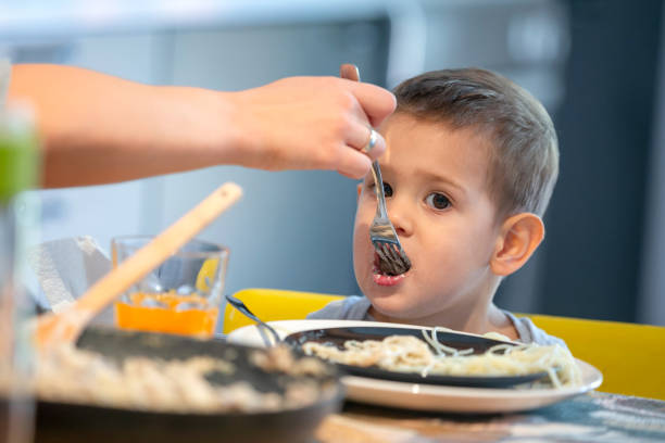 istock Feeding toddler spaghetti a the table 1267323790