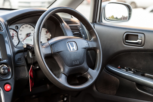 Novosibirsk, Russia - 08.05.20: The interior of an old Japanese car Honda Stream with a view of the dashboard, steering wheel, speedometer and logo with letter H.
