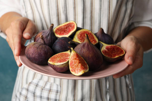 istock Woman hold plate with fig, front view 1267327094