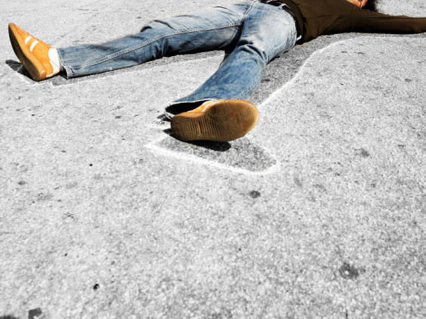 man lying in dead man chalk outline on concrete - crime scene chalk outline crime murder imagens e fotografias de stock