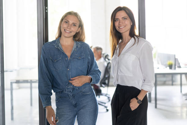 istock Two female collegues standing next to each other in an office. 1267329141