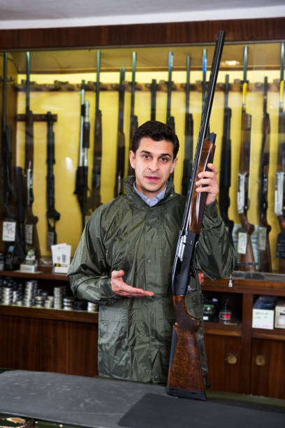 istock Man choosing rifle in shop 1267329324