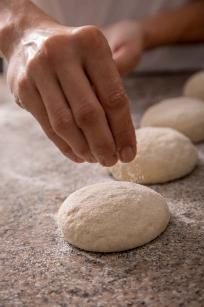 istock woman hands sprinkling pizza flour close-up 1267335712