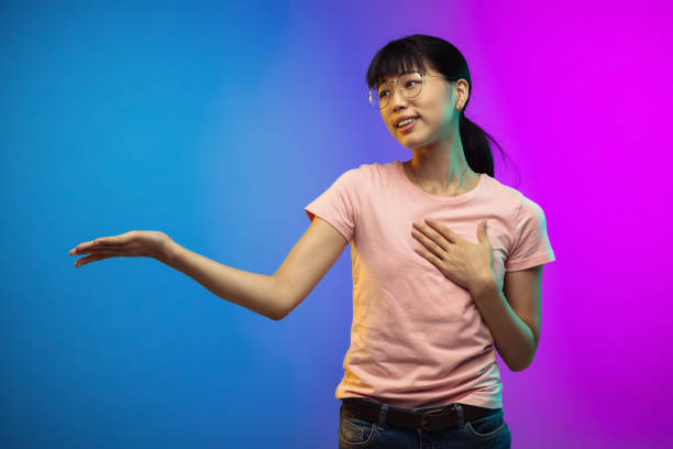 istock Asian young woman's portrait on gradient studio background in neon 1267337657