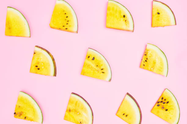 istock slices of yellow watermelon on a pastel pink background, copyspace, layout 1267337849