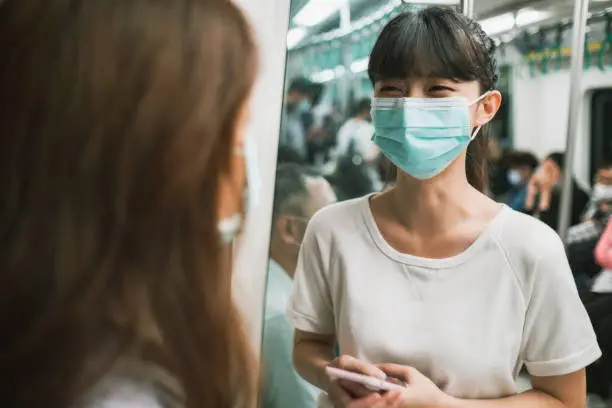 Photo of Girls wearing face mask for protection at subway station platform