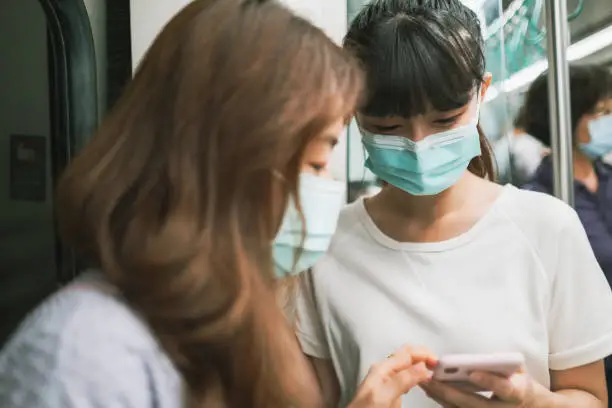 Photo of Girls wearing face mask for protection at subway station platform