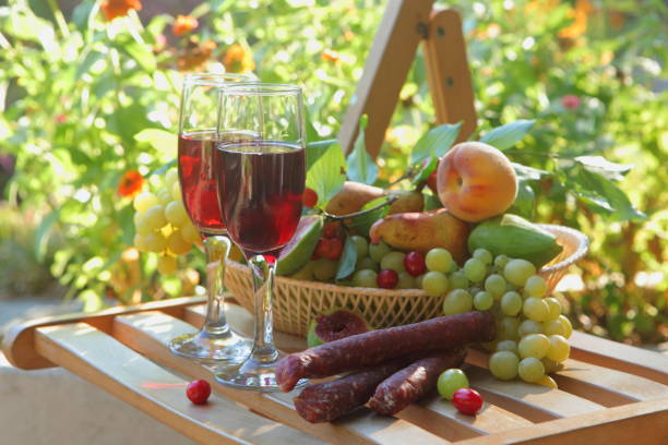 Still life with red wine, sausage and fruit