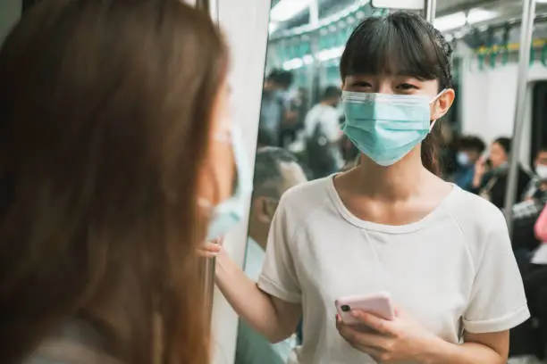 Photo of Girls wearing face mask for protection at subway station platform