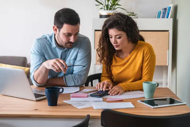 Photo of Young couple calculating their domestic bills at home stock photo