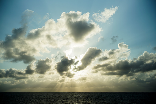 Dramatic scenery of backlit sky and sea in the evening at Miyako Island.\nThe sun shines brightly through the gaps in the clouds, and a radial line of light pours into the sea.\nPowerful sunshine, an impressive view.\nLight from heaven.