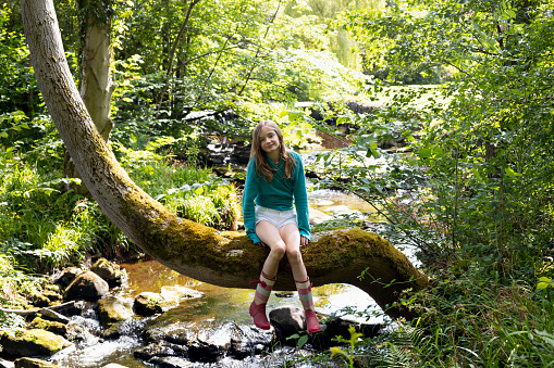 Girl in black dress outdoors in forest area.