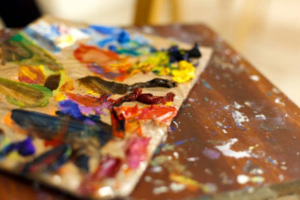 close-up of an easel with paints, the artist paints a brush. painting a picture - oilpaint imagens e fotografias de stock