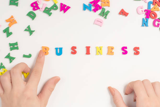istock Female hands lay out the word business from multi-colored letters 1267344314