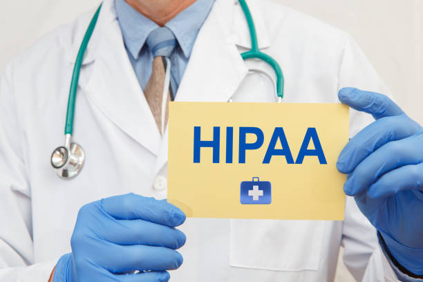 Close-up of a male doctor in gloves holding a sign with the text HIPAA stock photo