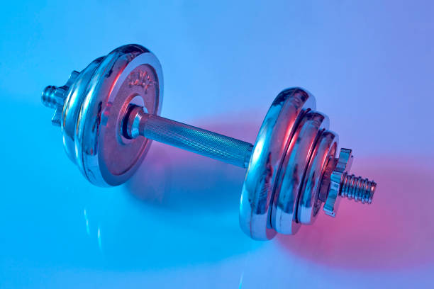 istock Dumbbell on the floor blue and pink lighting studio shot 1267346800