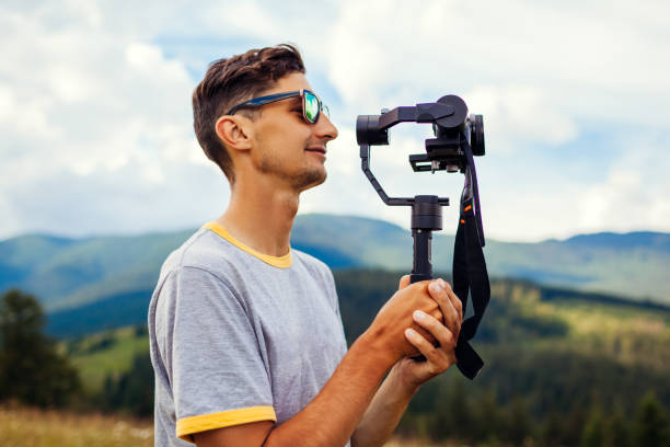 istock Videographer filming Carpathian mountains landscape. Man using steadicam and camera to make footage. Video shoot 1267348180