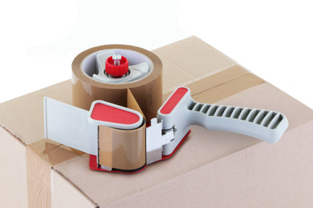 istock brown cardboard box and parcel tape dispenser 1267350054