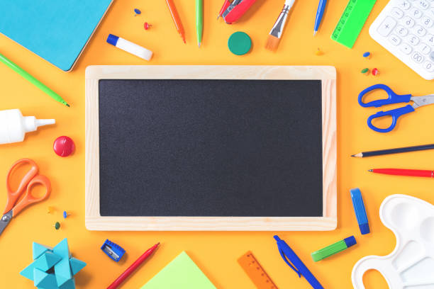 istock Assorted office and school stationery border on yellow 1267361034