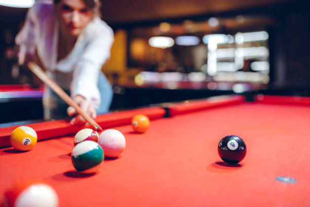 Young beautiful Caucasian woman playing pool.