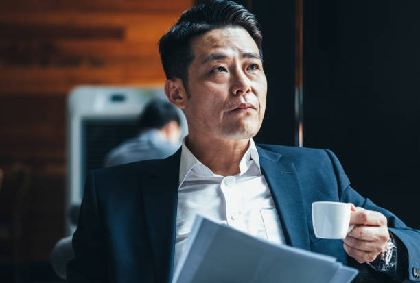 istock Business man having a coffee while reading documents stock photo 1267363140