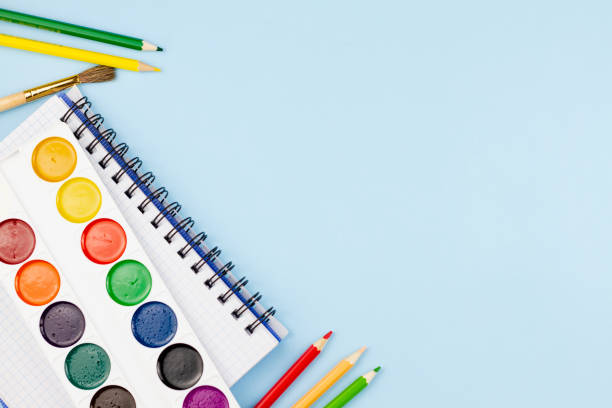 istock Watercolor with notepad and pencils on a blue background. 1267365214