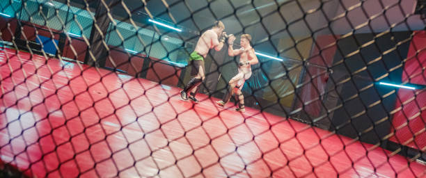 istock MMA fighters throwing punches in octagon. Knockout 1267368226