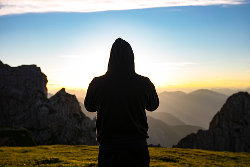 Silhouette of Adult Man in the Mountains at Sunset.
