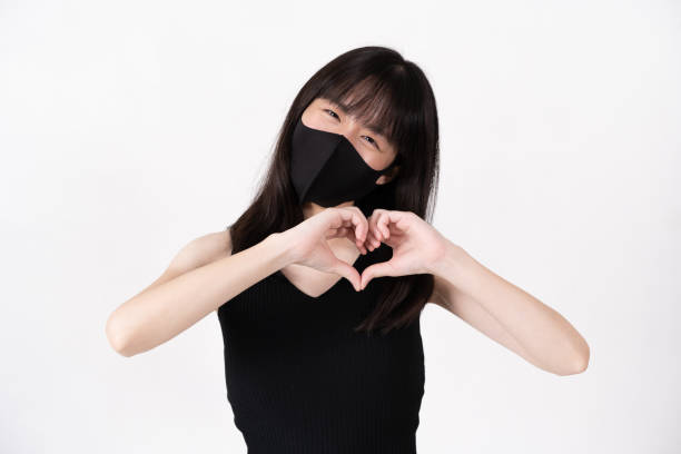 istock Asian woman wearing protective mask and making heart shape with hands 1267369755