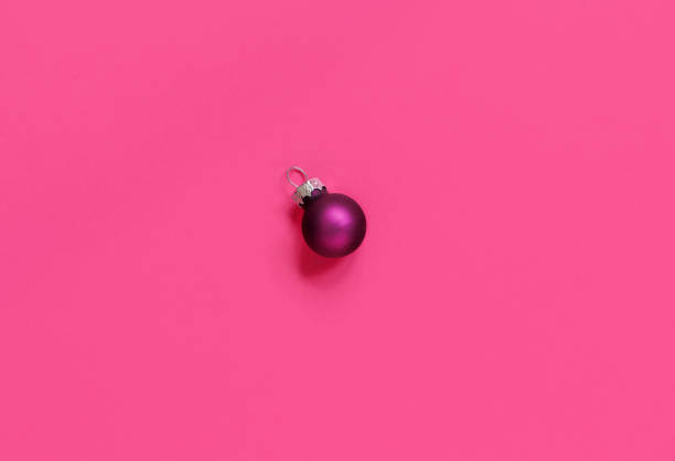 istock Purple Christmas bauble on a pink background 1267371224