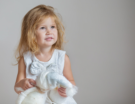 Little girl in costume of angel posing in studio