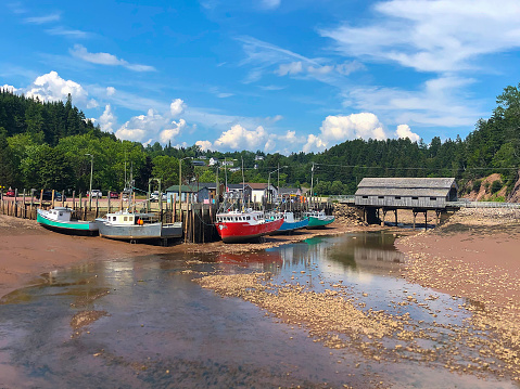 Colorful fishing boats in Atlantic Canada on the Bay of Fundy, St. Martins, New Brunswick during low tide