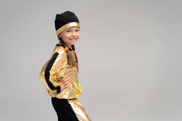 happy little girl in gold suit dancing isolated on white background. - gymnastics smiling little girls only isolated on white imagens e fotografias de stock