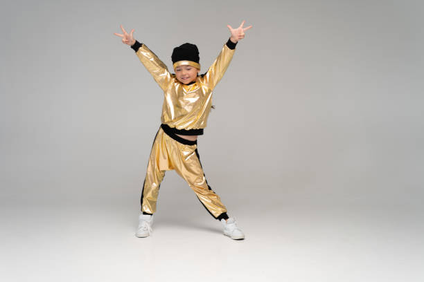 happy little girl in gold suit dancing isolated on white background. - gymnastics smiling little girls only isolated on white imagens e fotografias de stock