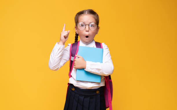 istock Little girl with school backpack pointing finger up, idea concept. 1267383273