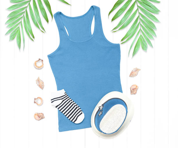 istock Blue tank top, shells and palm leaves on a white wooden background 1267384334