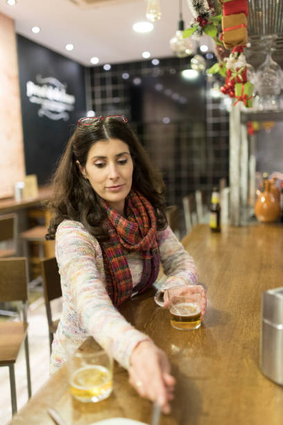 samotna kobieta w barze koktajlowym pije piwo i je tapas - spanish culture flash zdjęcia i obrazy z banku zdjęć
