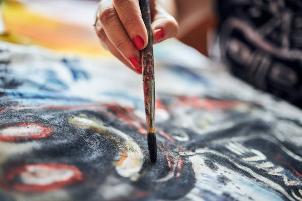 istock Unrecognizable female painter painting on a canvas 1267385791