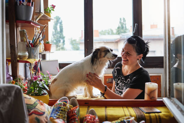 istock Cheerful painter stroking a dog in a home studio 1267385894